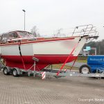 Zwischenstopp auf einem Autobahn Parkplatz. Bootstransport einer fertiggestellten Motoryacht fest verzurrt auf dem 10t-Trailer der Bootswerft Baumgart in Dortmund.