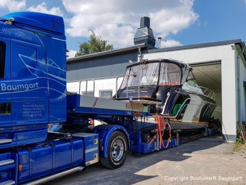 Die Scania Zugmaschine rangiert die Motoryacht in die Lackierhalle der Bootswerft Baumgart in Dortmund