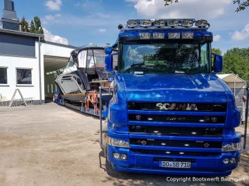 Die Scania Zugmaschine rangiert die Motoryacht in die Lackierhalle der Bootswerft Baumgart in Dortmund