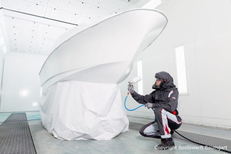 Stefan Baumgart in Schutzkleidung bei Bootslackierarbeiten in der Lackierkabine der Bootswerft Baumgart in Dortmund