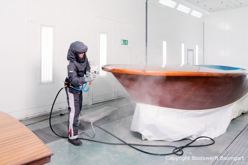 Stefan Baumgart in Schutzkleidung bei Holzlackierarbeiten in der Lackierkabine der Bootswerft Baumgart in Dortmund